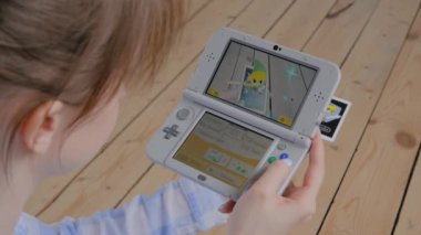 Oyun konsolu kullanan kadın oyuncu AR uygulaması ile Nintendo 3ds