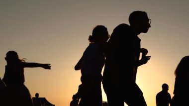Romantik çiftler gün batımında gökyüzüne karşı dans ediyorlar - süper yavaş çekim