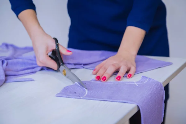 Handen van naaister snijden stof met schaar - close-up bekijken — Stockfoto