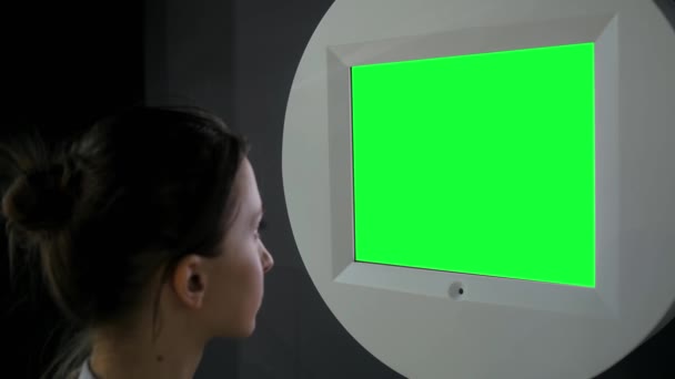 Donna che guarda parete verde vuota in mostra - concetto di schermo verde — Video Stock