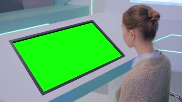 Femme regardant le kiosque d'affichage vert vierge à l'exposition concept d'écran vert — Video