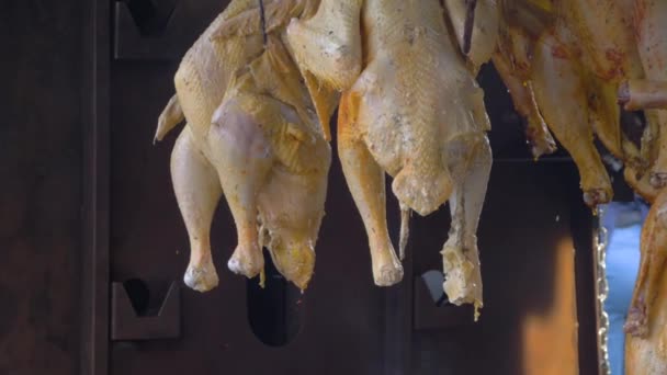 Hängende ganze Hühner rauchen über Feuer oder Kohlen im Sommer lokalen Lebensmittelmarkt — Stockvideo