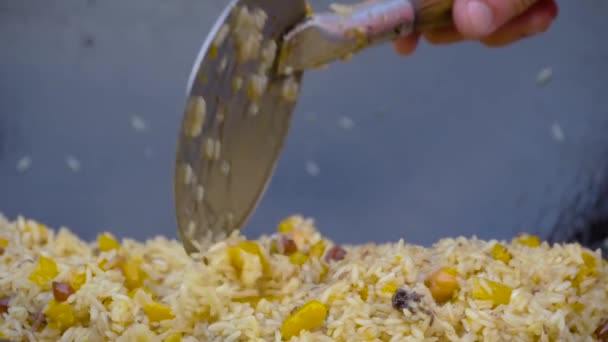 Movimento lento: chef cozinhar pilaf em caldeirão enorme no verão mercado de alimentos ao ar livre — Vídeo de Stock