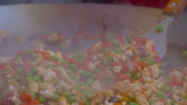 Yakın görüş: şef et parçaları, biber, bezelye büyük tavada - yavaş çekim