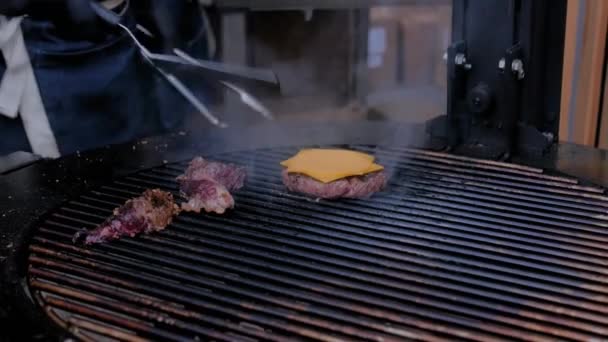 Close up view: chef cooking fresh pieces of meat and cutlet with cheese on grill — Stock Video