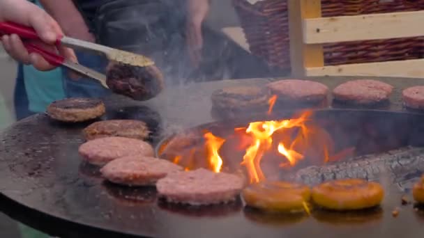 Rallentatore: cuoco grigliare costolette di carne per hamburger su braciere con fiamma calda — Video Stock