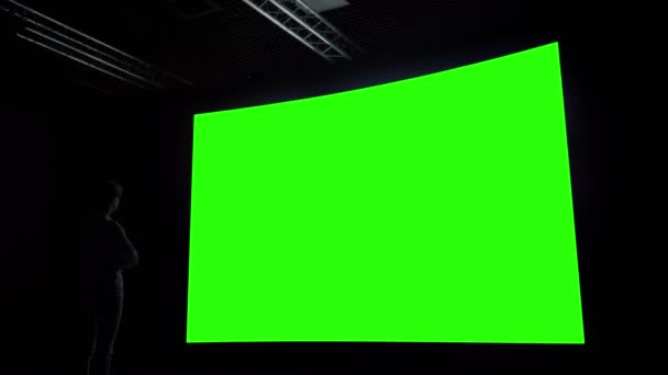 Kvinna tittar på tom stor interaktiv vägg display - grön skärm koncept — Stockvideo