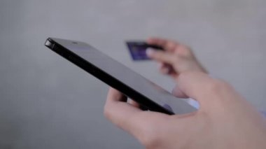 Kapat: akıllı telefon ve kredi kartını online alışveriş için kullanan kadın