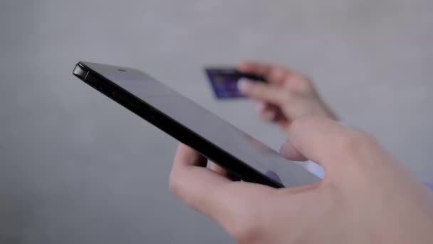 Kapat: akıllı telefon ve kredi kartını online alışveriş için kullanan kadın — Stok video