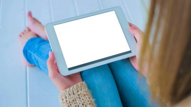Beyaz boş ekranlı tablet bilgisayara bakan kadın