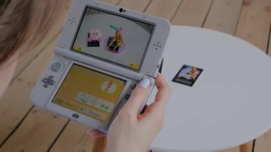 Oyun konsolu kullanan kadın oyuncu AR uygulaması ile Nintendo 3ds