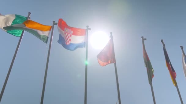 Diplomasi konsepti - yavaş çekim - rüzgarda dalgalanan renkli bayraklar — Stok video