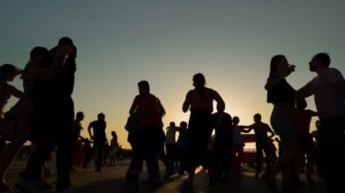 Romantik çiftler gün batımında gökyüzüne karşı dans ediyorlar - yavaş çekim
