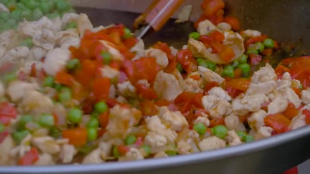 Vista da vicino: cuoco che cucina pezzi di carne, peperoni, piselli in wok enorme - slow motion — Video Stock