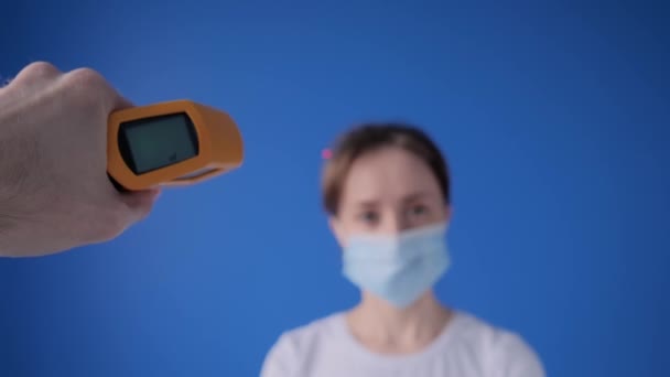 Slow motion: man hand met behulp van pyrometer om de lichaamstemperatuur van de vrouw te meten — Stockvideo