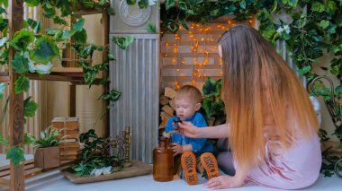 Mutlu genç anne ve küçük oğlu birlikte oynuyorlar.