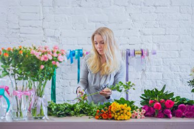 Çiçekçide çalışan profesyonel bir çiçekçi.