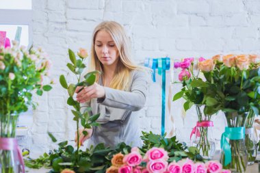 Stüdyoda çiçeklerle çalışan profesyonel bir çiçekçi.