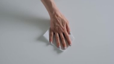 Ağır çekim: beyaz masayı ıslak mendille temizleyen kadın - üst görünümü kapat