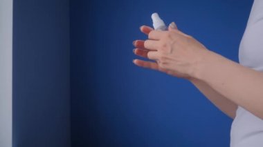 Ağır çekim: kadın ellerine antiseptik püskürtüyor - yakın çekim - sprey dezenfeksiyon
