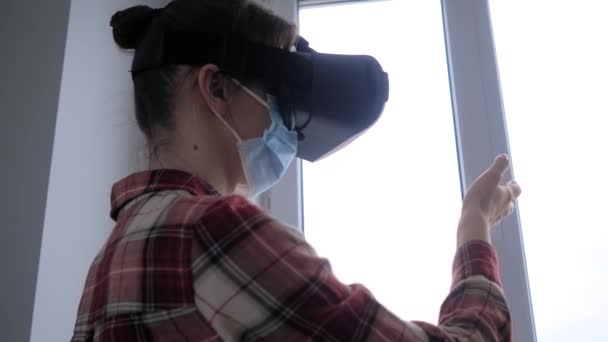 Jovem mulher vestindo máscara facial médica e fone de ouvido realidade virtual conceito VR — Vídeo de Stock