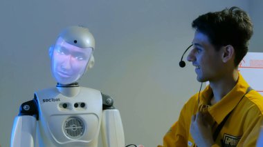 Rehber adamla konuşan komik insansı robot.