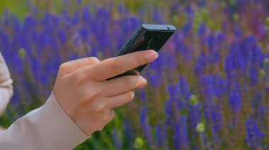 Parkta akıllı telefon kullanan kadın.