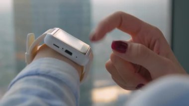 Ofiste takılabilir beyaz akıllı saat kullanan kadın eli - yan görünümü kapat