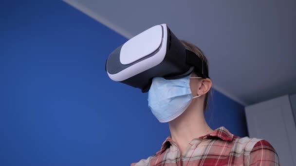 Junge Frau mit medizinischer Gesichtsmaske und Virtual Reality Headset - VR-Konzept — Stockvideo