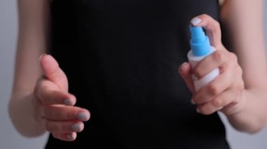 Ağır çekim: kadın ellerine antiseptik püskürtüyor - yakın çekim - sprey dezenfeksiyon