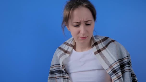 Slow motion: kvinna illamående, nysningar i ansiktet vävnad mot blå vägg — Stockvideo