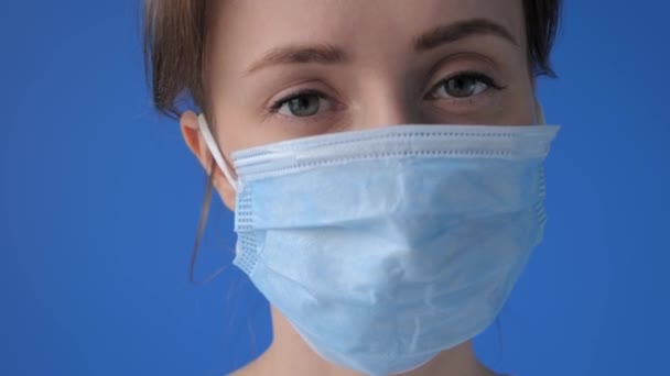 Woman wearing medical face mask, looking at camera: quarantine concept, closeup — Stock Video