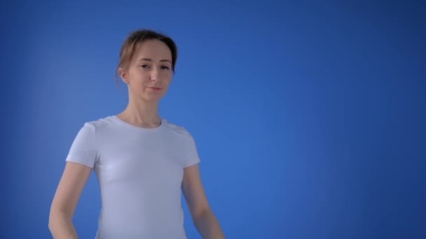 Медленное движение: женщина надевает медицинскую маску для лица и смотрит на камеру дома — стоковое видео