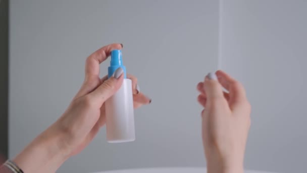 Повільний рух: жінка розбризкує антисептик на руках - крупним планом - дезінфекція спреєм — стокове відео