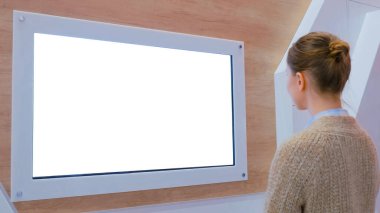 Beyaz ekran, maket, gelecek, telif alanı, şablon, izole edilmiş, teknoloji konsepti. Sergi veya müzede içi fütürist bilim kurgu içerikli boş dijital etkileşimli beyaz ekran duvarına bakan kadın