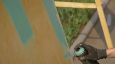 Adam graffiti festivalinde konserve kutusundan boya püskürtüyor. Yavaş çekim.