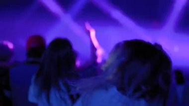 Ağır çekim: genç kız rock konserinde sahnenin önünde parti yapıyor.