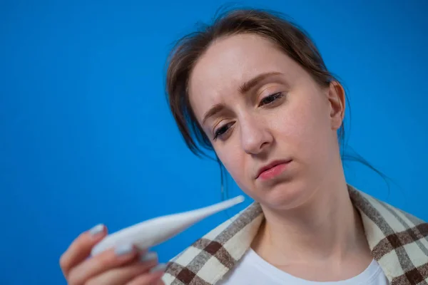 Retrato de mulher sentindo-se doente, olhando para o termômetro médico em casa — Fotografia de Stock