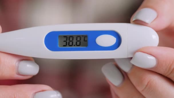 Movimiento lento: mujer sosteniendo termómetro médico digital con alta temperatura — Vídeos de Stock