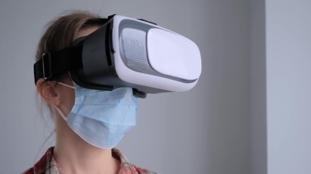 Jovem mulher vestindo máscara facial médica e fone de ouvido realidade virtual conceito VR — Vídeo de Stock