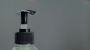 Kadın şeker kutusunu itiyor, antiseptik jel sıkıyor. Yaklaş, yavaş çekimde.