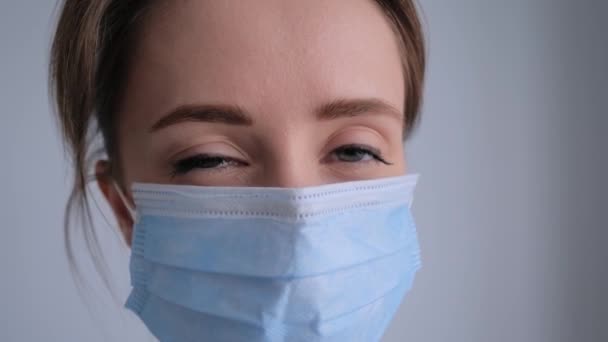Concepto de autoaislamiento - mujer que usa mascarilla médica, mirando a la cámara — Vídeo de stock