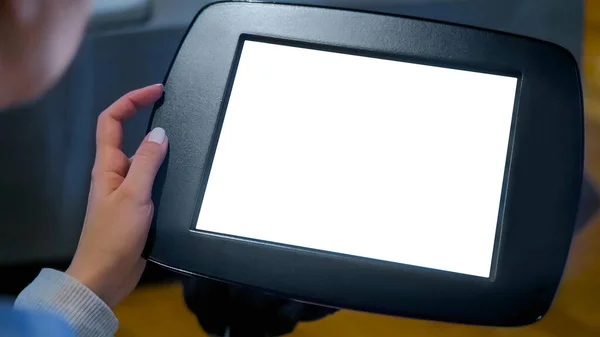 Kadın boş beyaz ekranlı siyah tablet büfeye bakıyor.