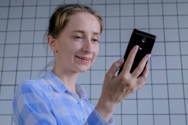 Akıllı telefon kullanan, görüntülü konuşma yapan, röportaj yapan ya da danışmanlık yapan bir kadın