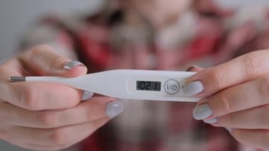 Yakın çekim: yüksek sıcaklıkta dijital medikal termometre tutan kadın