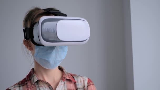 Mladá žena v lékařské masce obličeje a virtuální reality headset - VR koncept — Stock video