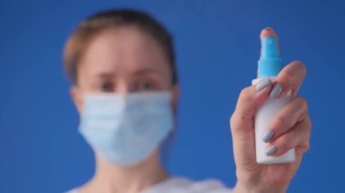 Ağır çekim: kadın kameraya antiseptik püskürtüyor - yakın çekim, seçici odaklanma