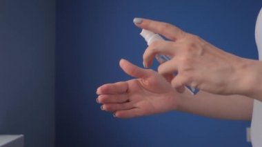 Ağır çekim: kadın ellerine antiseptik püskürtüyor - yakın çekim - sprey dezenfeksiyon