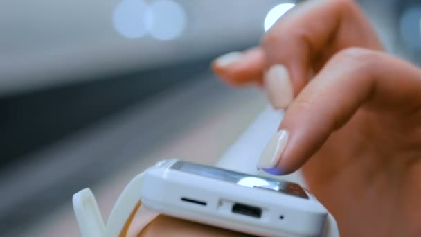 Femme utilisant la montre intelligente blanche sur la plate-forme du métro — Video