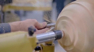 Yakın çekim: marangoz torna üzerinde odun parçasını şekillendirmek için keski kullanıyor: yavaş çekim